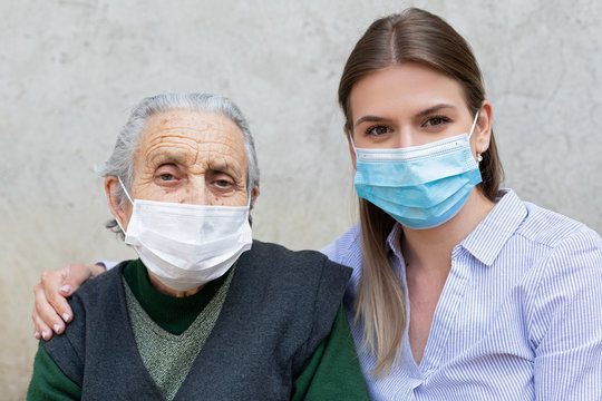 Caregiver With Elderly Ill Woman Wearing Mask