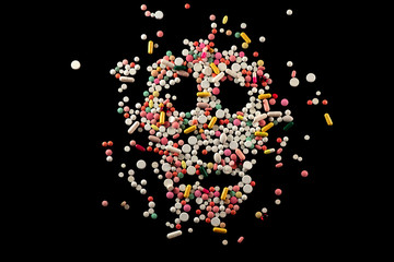 The ill effects of drugs.
Skull with colored pills on black background