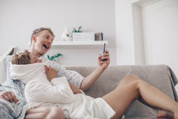 Couple in love phone. Sofa. Home concept. Smile man. Male. Sensual. 