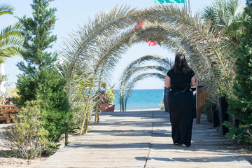 
woman walking towards the horizon on a beach
