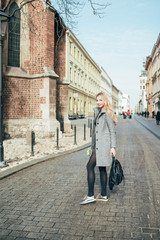 Fototapeta na wymiar young blond beautiful woman walking on city street