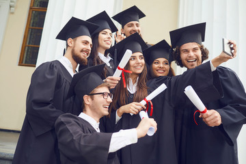 Students graduates are photographed on the phone at the university college.
