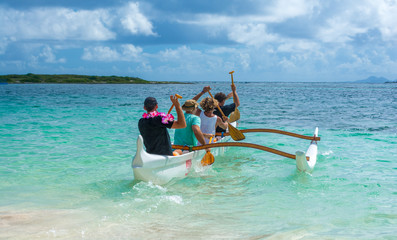 Rameurs en mer dans une pirogue à balancier