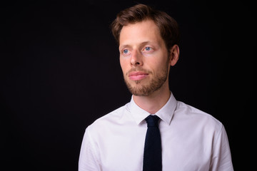Face of handsome bearded businessman thinking and looking away