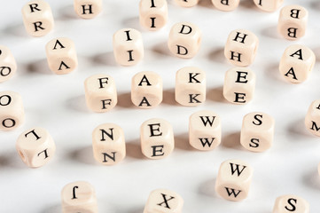 Light background with wooden cubes and letters. FAKE news as a concept