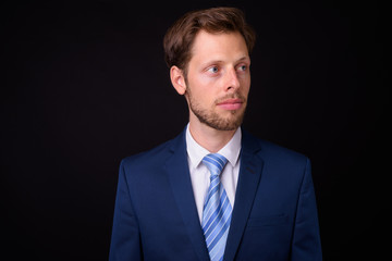 Face of bearded businessman in suit thinking