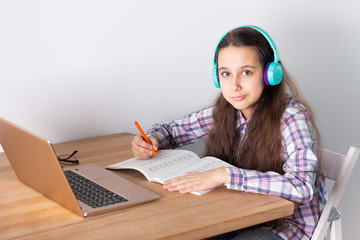 Distance learning at home.Student with a laptop listening to a webinar online with headphones. Elearning concept.