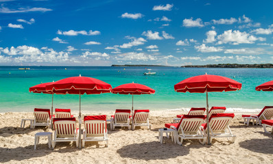Transats et parasol rouges sur la plage