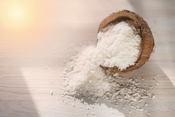coconut flakes lies in a coconut shell, cut into two halves
