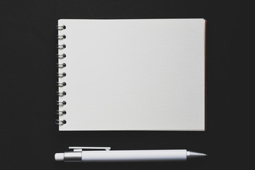 Blank notepad and pen on office black table