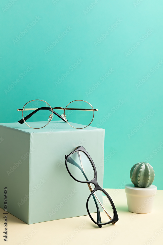 Wall mural stylish eyeglasses over pastel background. optical store, glasses selection, eye test, vision examin