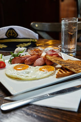 Breakfast meal - eggs, toasts, sausages, greenery photo. Marine theme and interior background