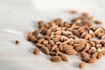 on a light wooden background lies almonds