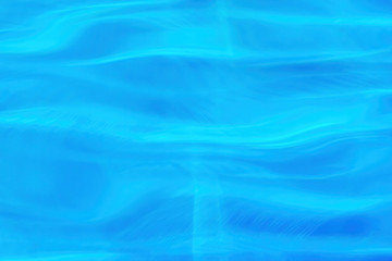 Water surface in the blue swimming pool, shiny aqua splashes and waves. Background pattern.