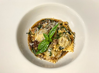 RAVIOLI HOMEMADE WITH WINE SAUCE ON A WHITE PLATE
