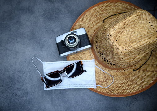 Urlaubs-Accessoires 2021: Schutzmaske, Sonnenhut, Sonnenbrille und Fotoapparat