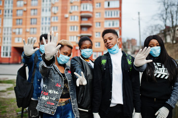 Group of african teenagers friends against empty street with building wearing medical masks protect from infections and diseases coronavirus virus quarantine.