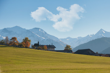 kitzsteinhorn und imbachhorn im herbst unter wolken blauem himmel gesehen von schloß kammer zell...