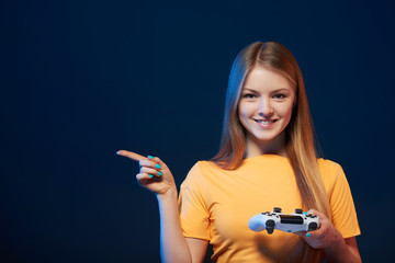 Happy girl holding video game joystick pointing finger to side © paffy