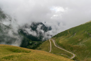 The road that crosses the Fagaras mountains seen from above among the fog, Transfagarasan, Romania