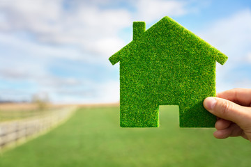 Green ecological house in empty field