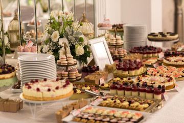 Delicious candy bar with macaroons, cupcakes and other sweets