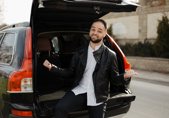 Portrait of fashionable well dressed man with beard posing outdoors