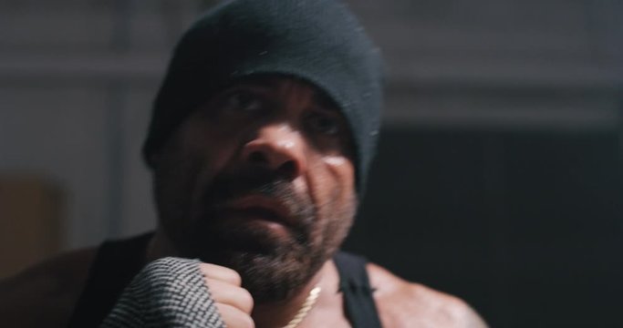 Muscular, tan, bearded, man shadow boxes with fists and jabs.