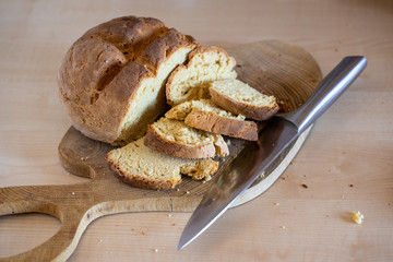 Freshly baked irish soda bread cutted into slices with big knife lying on the side. Healthy, homemade, delicious pastry.