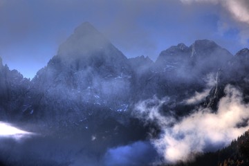 High Alpine mountains rising through the clouds