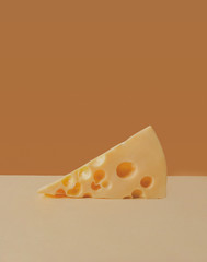 a triangular piece of cheese Maasdam with holes. minimalism and creative. Space for text