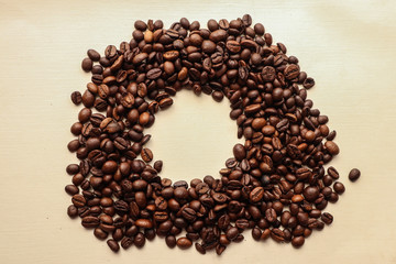 Coffee grains with space for text on brown paper background
