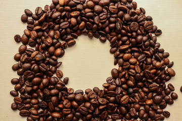 Coffee grains with space for text on brown paper background