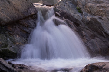 Fototapeta na wymiar long exposure shot of a waterfall falling down between the rocks