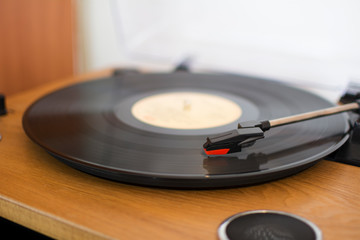 Closeup of a wooden record player with a vinyl playing music