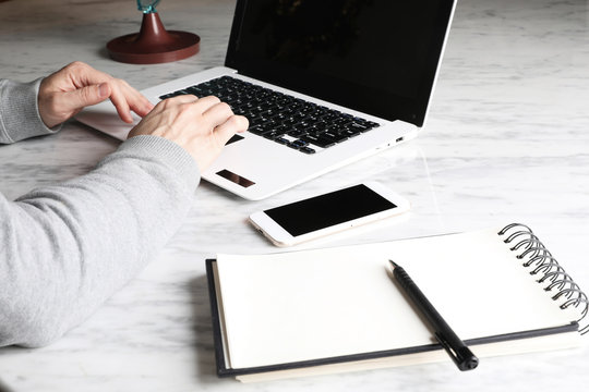 Mock-up Of Man Hands Using Laptop On White Marble Surface.