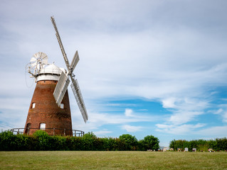 Thaxted Windmill. A traditional old English windmill near the Essex village of Thaxted set against a blue summer sky. © pxl.store