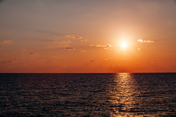 Naklejka na ściany i meble Beautiful warm sunset on the sea. Beautiful scenery. Charming sunset