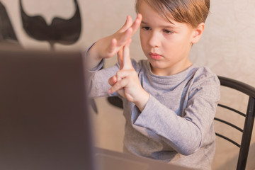 A focused smart toddler children boy is engaged in an online school at home a Neuro gymnastics...