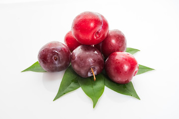 plums with plum leaves isolated on a white background