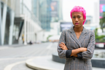 Young rebellious Asian businesswoman with arms crossed in the city streets