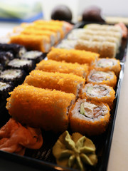 Sushi stands in open takeaway boxes at the sushi bar