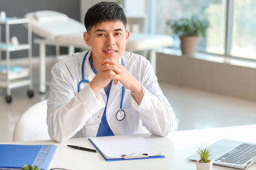 Naklejka premium Male Asian doctor working in clinic