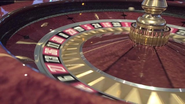 Close up of roulette wheel spinning roulette in a casino where the ball goes to the green or red or black number