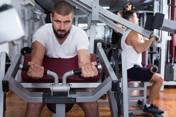 Fototapeta na wymiar Man on power exercise machine in gym