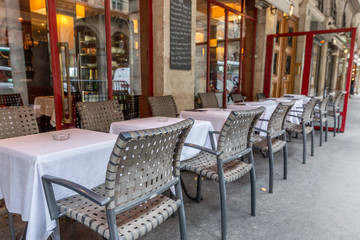 Fototapeta na wymiar Empty tables in a european street cafe. Quarantine during the coronavirus pandemic. Sad mood.