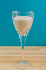 Two glasses with a banana smoothie of chocolate and ice cream on a blue background.
