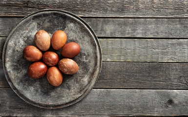 Red-brown colored eggs lie on a wooden background.