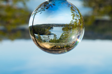 Beautiful landscape in glass ball with icy lake in the national park Repovesi, Finland