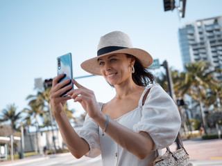 Fototapeta premium Happy young woman with a phone on the beach